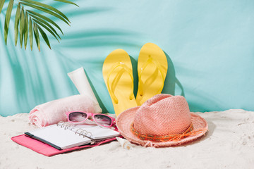 Summer accessories on sandy beach. Summer exotic relaxation concept. Copyspace for text
