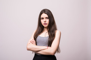 Fototapeta premium Portrait of beautiful business woman standing with hands folded and looking at camera over white background
