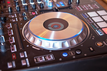 DJ console cd mp4 deejay mixing desk Ibiza house music party in nightclub with colored disco lights.