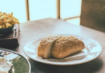 Ciabatta in white plate on wooden table
