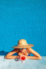 Woman at poolside with cosmopolitan cocktail