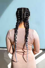 fashionable hairstyle of two braids with a kanekalon on a figurehead brunette, a girl with long braids, sexy