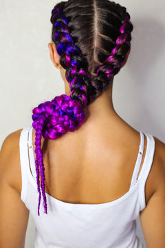 the girl is braided with two braids with purple and pink artificial material kanekalon
