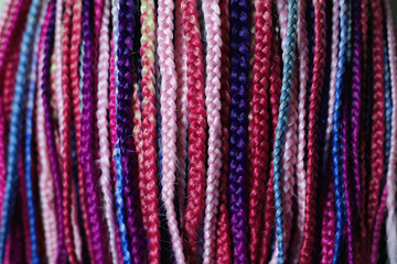 set of thin colored afrokosichek, pink shades of kanekalon, multi color, texture, background of plaits