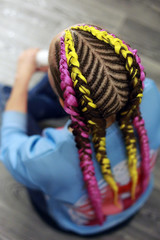 thick colored braids with kanekalon, pink hair, close-up of braid, master holds in hand, ready hairdo in close-up detail