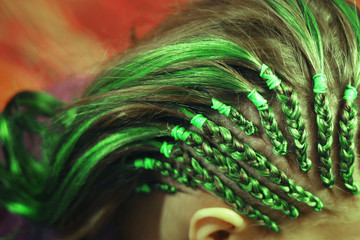 Breydas on temples with an interlacing of a colorful kanekalon, close-up drawing, green hair, blue hair, hair of neon shades