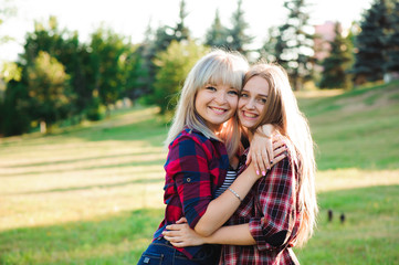 Fototapeta premium Two girls friends laughing and hugging. Hug and smile outdoor