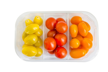 Colorful cherry tomatoes isolated on white for your design. Assortment, different colors: red, orange and white in plastic box. Top view.