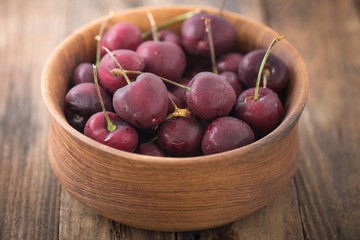 Cherry on wooden table with water drops macro background

