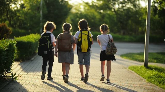 Group of Pupils with School Backpacks Are Going Back to School. They Are Having a Lot of Fun.