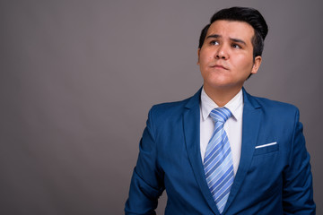 Young multi-ethnic businessman against gray background