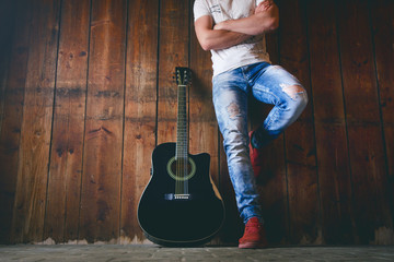 Acoustic guitar on a wooden texture with copy space for a text and guitar player. Music and leisure...