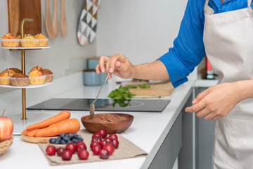 Closed up on women hand doing a chocolate smoothies in the kitchen.