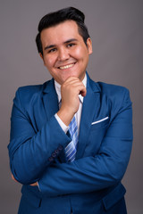 Young multi-ethnic businessman against gray background