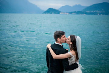 wedding couple kissing on the background of a lake and mountains