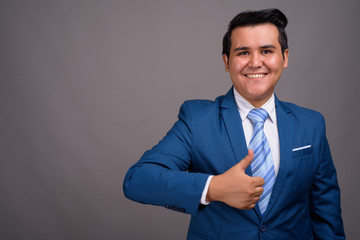 Young multi-ethnic businessman against gray background