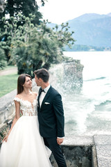 wedding couple kissing on the background of a lake and mountains