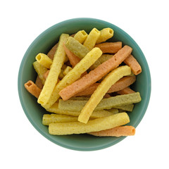 Top view of veggie straws in a green bowl isolated on a white background.