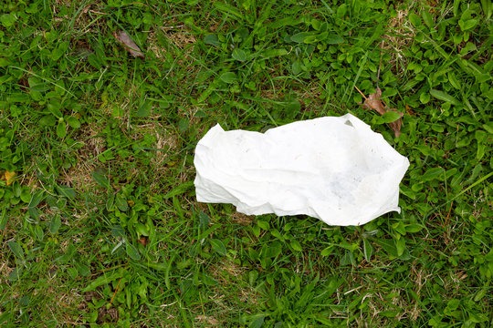 Piece of white paper trash on a field.