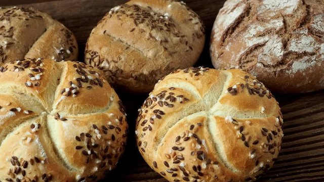Freshly baked bread. Various crusty bread and buns on wooden table.