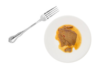 Tilapia fillet in sesame sauce on a plate with a fork to the side isolated on a white background.