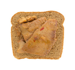 Tilapia fillet in sesame sauce on wheat bread isolated on a white background.