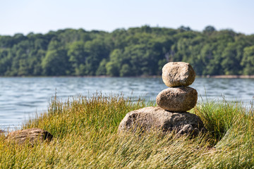 Stacked rocks on the coast of Maine with Sears Island in the background.