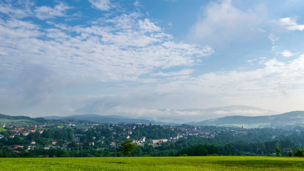 Blick vom Berg in das Thal über eine kleine Stadt im bayerischen Wald 