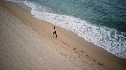 Barcelona, Spain, Mediterranean sea. The girl runs along the seashore
