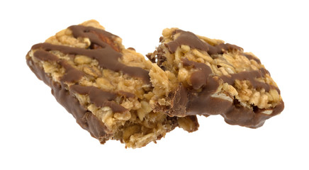 Side view of a chocolate with nuts granola bar broken in half isolated on a white background.