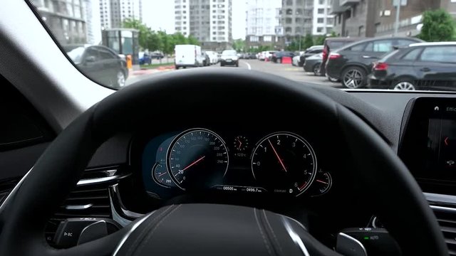 View of car dashboard while driving in city.