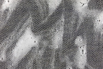 Close view of a gray shirt with liquid cleaner worked into the cloth.