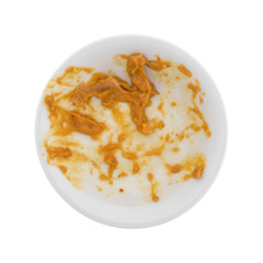 Top view of a bowl of curry flavored tuna that has been eaten isolated on a white background.