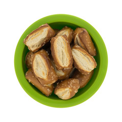 Top view of bite size sourdough pretzels in a green bowl isolated on a white background.