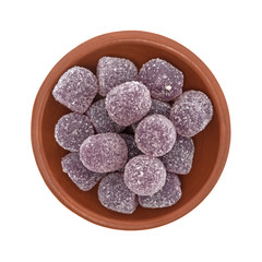 Top view of sugar coated grape sour drop gummy candy in a bowl isolated on a white background.