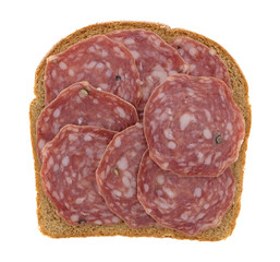 Slices of uncured soppressata dry salami on bread isolated on a white background.