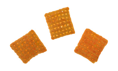 Top view of three cheddar cheese crispy rice crackers on a white background.