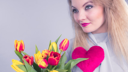 Woman holds tulips and red heart