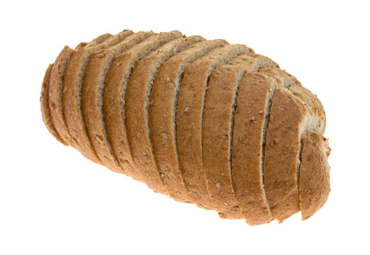 Side view of a small loaf of sliced wheat bread isolated on a white background.