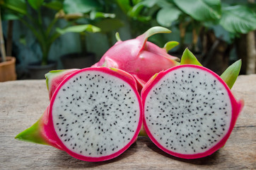 Dragon fruit cut in half on old wood.