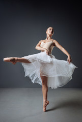 Fototapeta na wymiar Young cute ballerina training and demonstrating her plasticity.
