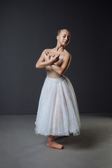 Fototapeta premium Pretty concentrated dancer standing and holding crossed her hands.