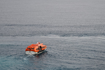 orange rescue boat or life boat sails on the sea