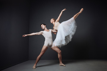 Young reliable dancer standing and supporting his partner.