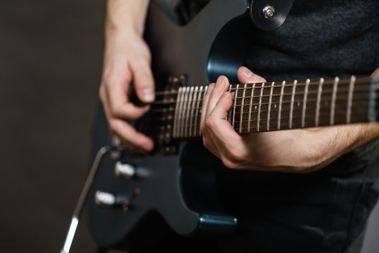 Male hands playing electric guitar