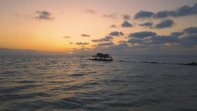 Vista aerea di sagome dei trabucchi sul mare per la pesca del pesce con pescatori alle ultime luci del tramonto.