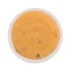 Top view of melted dipping cheese in a small bowl isolated on a white background.