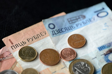 Belarusian banknotes and coins scattered on the surface close up
