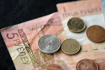 Belarusian banknotes and coins scattered on the surface close up