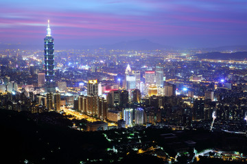 Aerial panorama of busy Taipei City with view of Taipei 101 in downtown area, Tamsui River and distant Mountains in evening twilight ~ A romantic scenery of Taipei City under beautiful evening sky